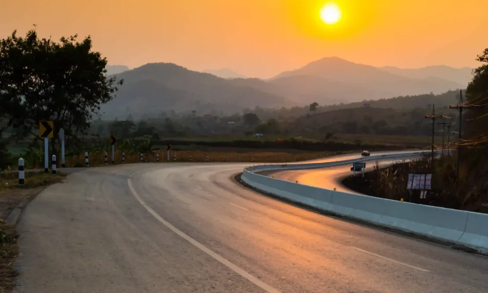 road-by-trees-against-orange-sky-sunset